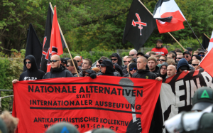 Block vom „Antikapitalistisches Kollektiv" am 1. Mai 2015 in Saalfeld, rechts am Frontransparent mit Glatze und gelben Brustemblem: Felix Reck aus Saalfeld, inzwischen gewaltsuchendes Mitglied bei der „Anti Antifa Ostthüringen"